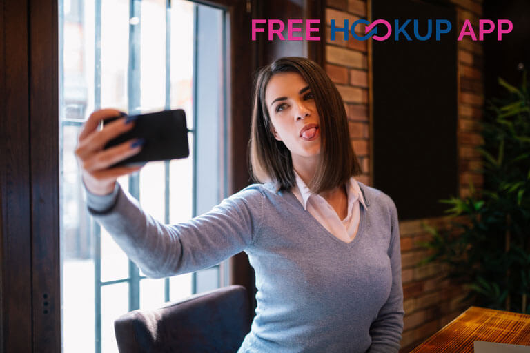 cute girl in cafe browsing free hookup app on phone